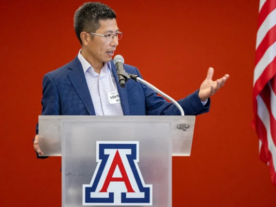Michael Wu speaks from a University of Arizona podium