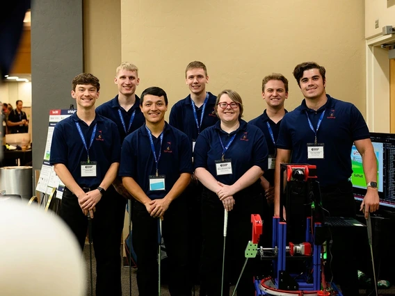 group of students wearing blue polo shirts and lanyards, holding golf clubs