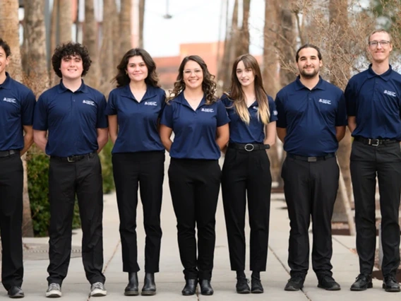 group of students wearing blue polo shirts and black pants