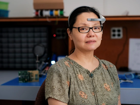 person with dark hair and glasses wearing headset