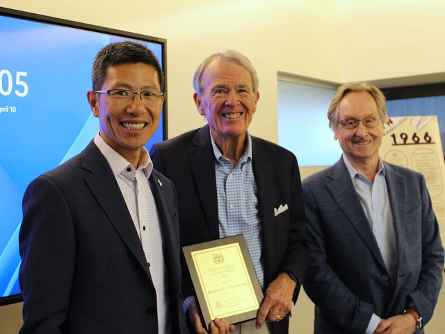 Three men with the center one receiving an award. 