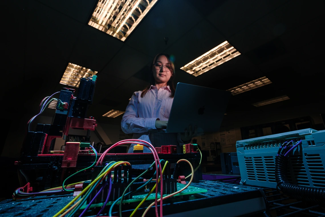 A woman stands near electrical wires.