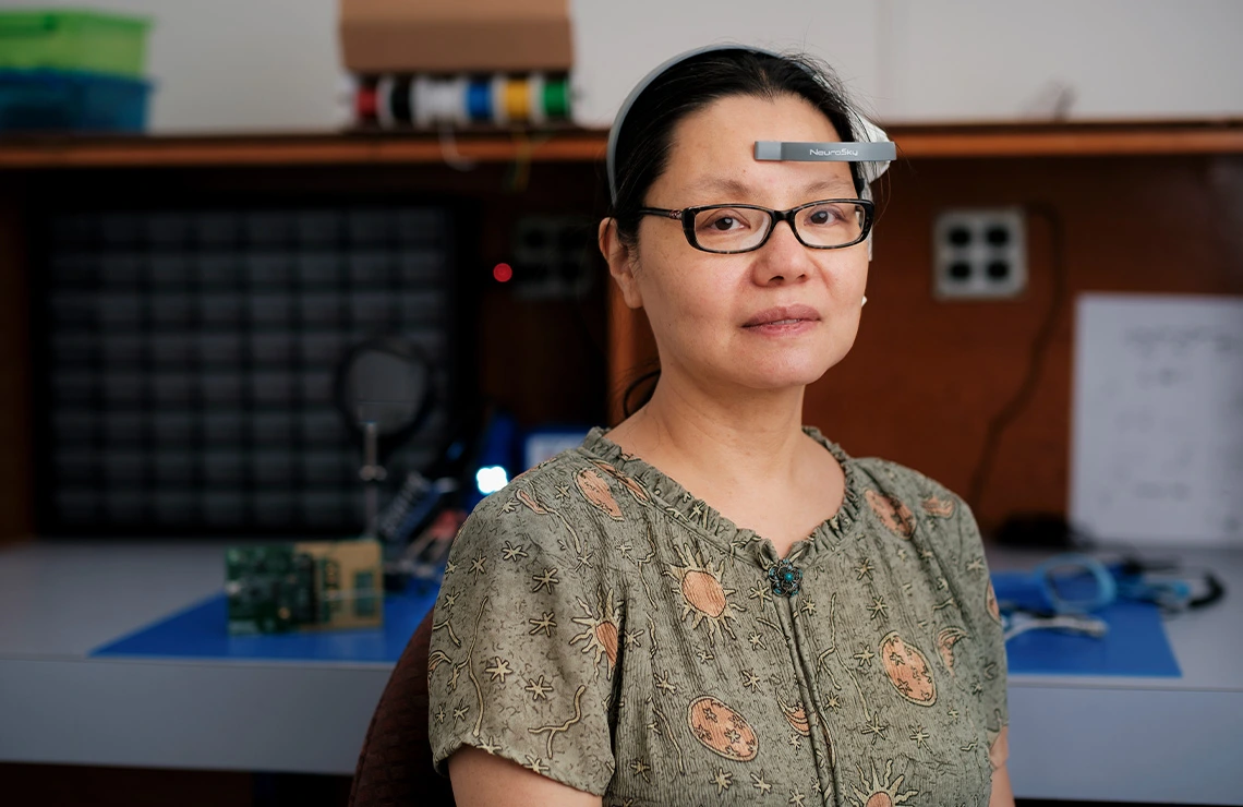 person with dark hair and glasses wearing headset