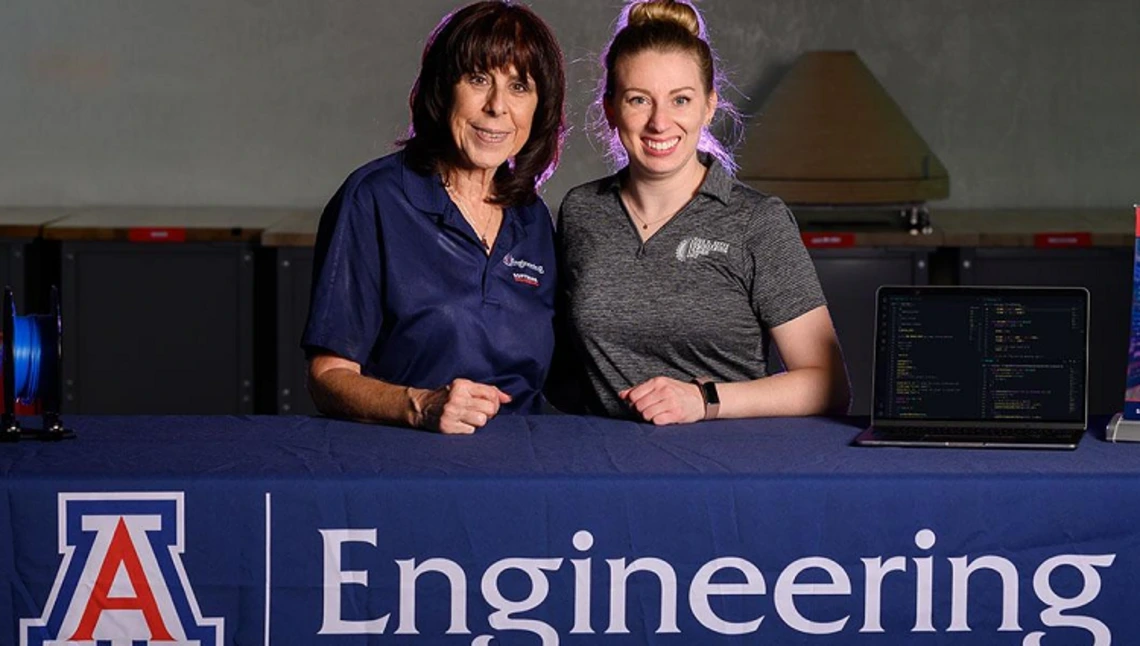 two people, standing behind Univ of AZ Engineering tablecloth