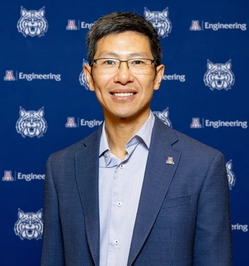 man wearing glasses, standing in front of U of A College of Engineering backdrop