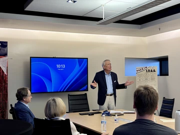 Man addressing audience in conference room. 