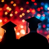 silhouette of two graduates with yellow, red and blue lights in background