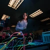 A woman stands near electrical wires.