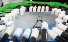 A white tank has a ring of tubes that flow water.
