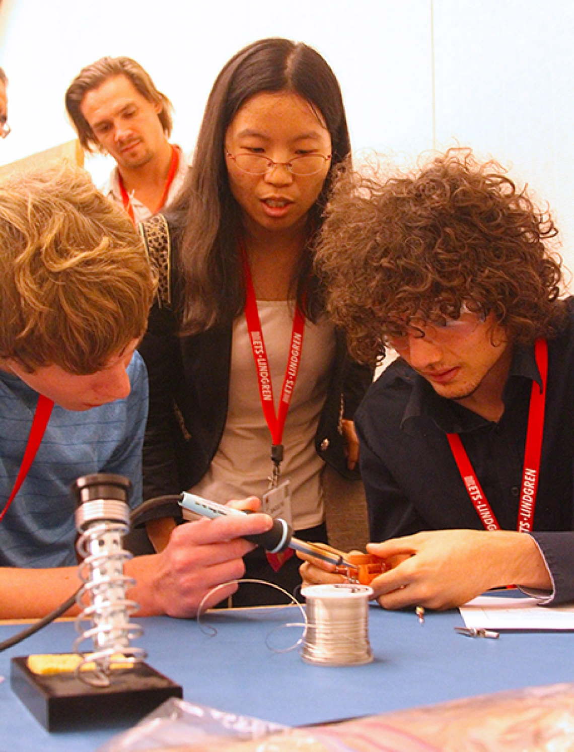 three students, soldering