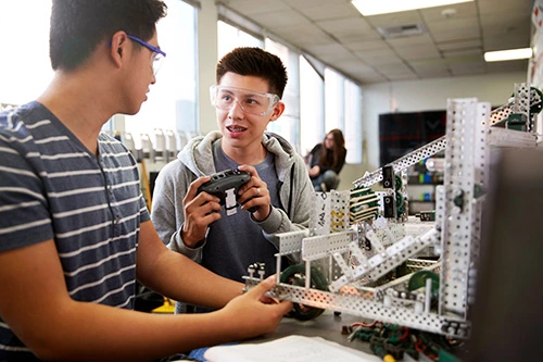 two people in lab, building a robotic device