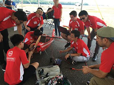 Photo of team doing pre-flight check for model airplane