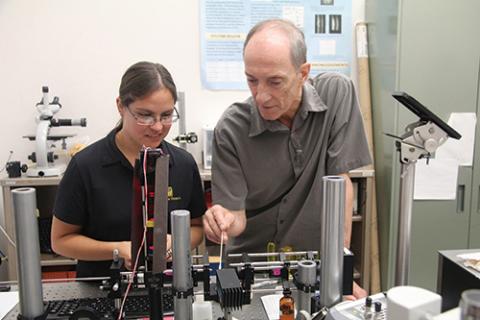 Photo of Raymond Kostuk and student testing a bench-top imaging instrument.