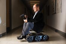 Wolfgang Fink with two of his inventions: a smart ophthalmoscope cell phone application, and a planetary rover