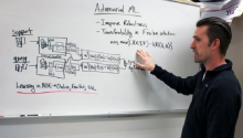 Gregory Ditzler points at a whiteboard covered in a series of math equations. The top says "Adversarial ML."