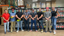 Six interns stand at the Sahuarita Food Bank surrounded by shelves full of food