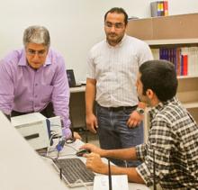 From left, ECE Professor Marwan Krunz and doctoral students Wessam Afifi and Hanif Rahbari (seated) analyze wireless transmission signals in the lab.