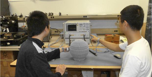Students in Hao Xin's lab perform measurements on a 3-D printed prototype of a Lüneburg lens. 