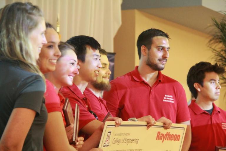 ECE students Jeremy Gin, Mark Roche and Jaime Lara Martinez accept the Raytheon Sensintel Best Overall Design Award with their teammates at the 13th annual Engineering Design Day.